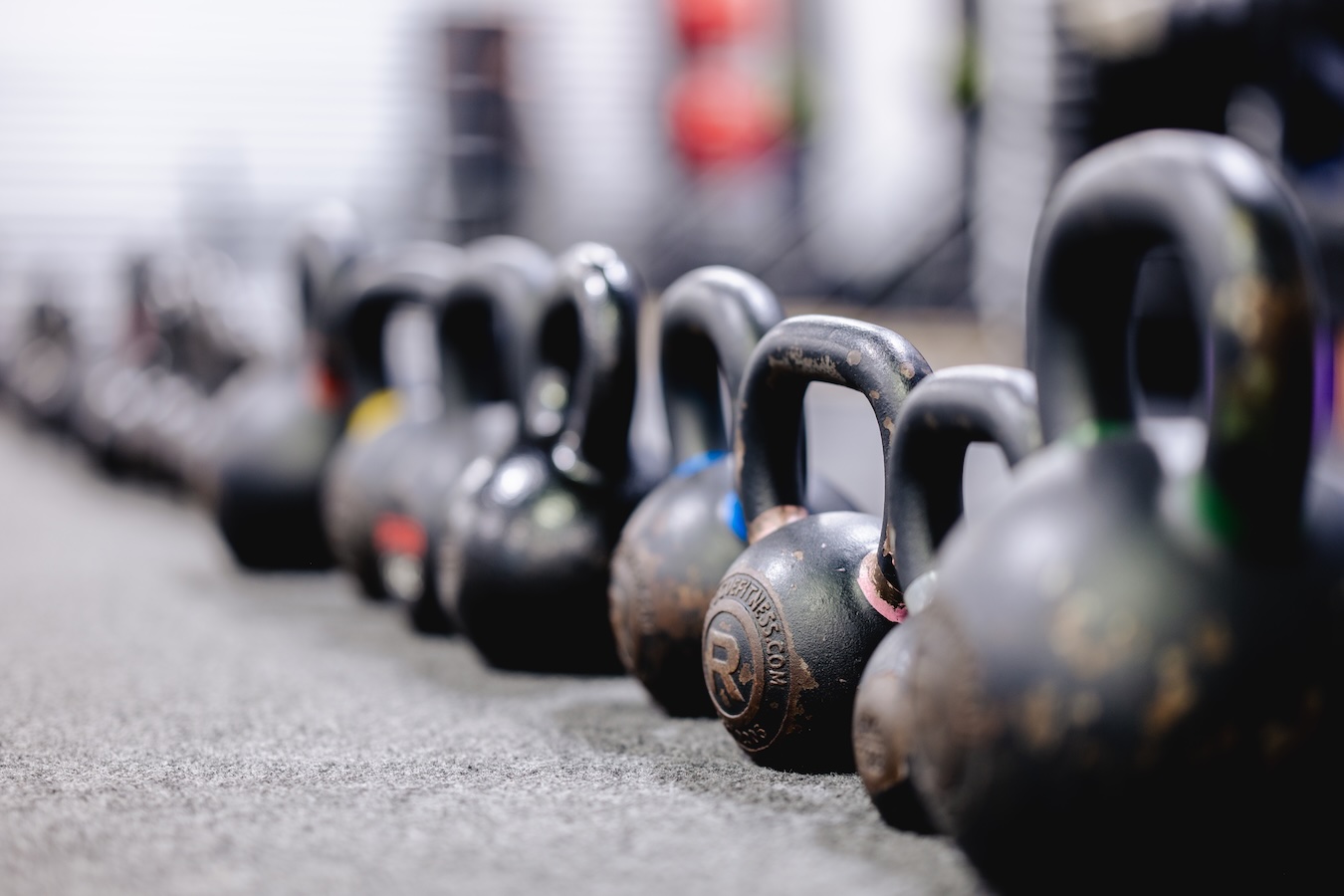A row of different sized kettlebells in a Fit Body Boot Camp.