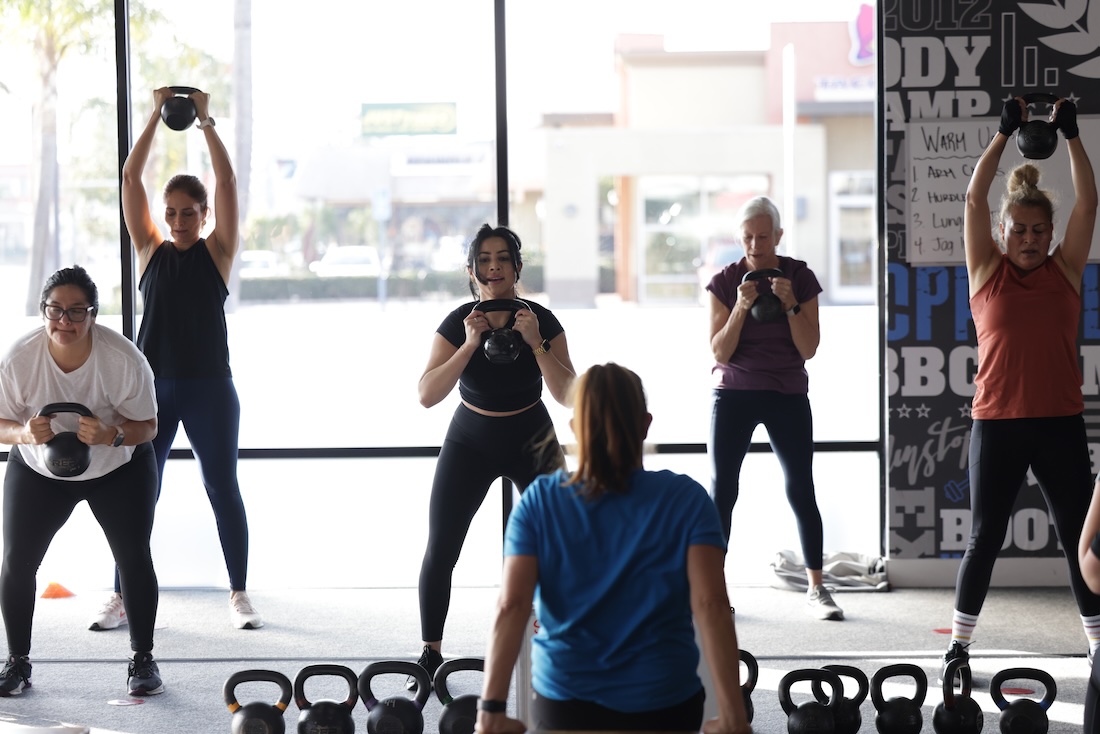 Fit Body Boot Camp class using kettlebells during circuit training.